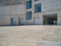 the gray concrete walls of a building have a line of steps on the left side