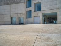 the gray concrete walls of a building have a line of steps on the left side