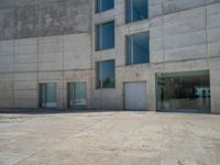 the gray concrete walls of a building have a line of steps on the left side