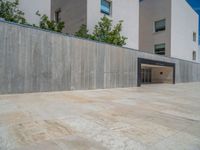 the gray concrete walls of a building have a line of steps on the left side