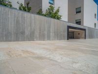 the gray concrete walls of a building have a line of steps on the left side