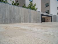 the gray concrete walls of a building have a line of steps on the left side