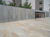 the gray concrete walls of a building have a line of steps on the left side