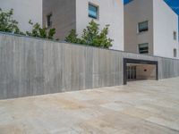 the gray concrete walls of a building have a line of steps on the left side