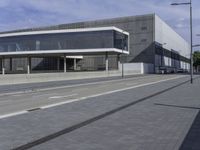 the entrance to the new state library building is shown from an angle of view, on a cobblestone walk