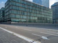 the road is empty on this busy street with the tall building in the background for pedestrians