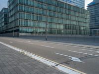 the road is empty on this busy street with the tall building in the background for pedestrians