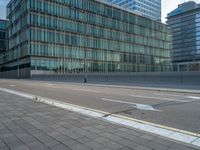 the road is empty on this busy street with the tall building in the background for pedestrians