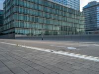 the road is empty on this busy street with the tall building in the background for pedestrians