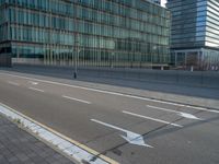 the road is empty on this busy street with the tall building in the background for pedestrians