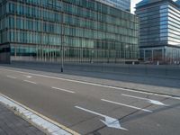 the road is empty on this busy street with the tall building in the background for pedestrians