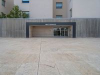 empty area outside concrete building with no people or vehicles at the entrance to area behind it