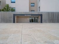 empty area outside concrete building with no people or vehicles at the entrance to area behind it