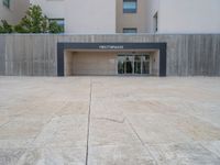 empty area outside concrete building with no people or vehicles at the entrance to area behind it