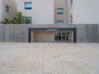 empty area outside concrete building with no people or vehicles at the entrance to area behind it