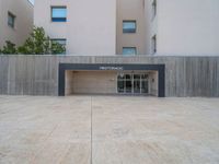 empty area outside concrete building with no people or vehicles at the entrance to area behind it