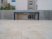 empty area outside concrete building with no people or vehicles at the entrance to area behind it