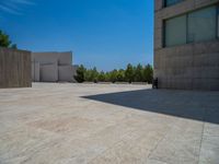 the gray concrete walls of a building have a line of steps on the left side