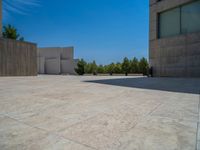 the gray concrete walls of a building have a line of steps on the left side