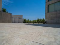 the gray concrete walls of a building have a line of steps on the left side