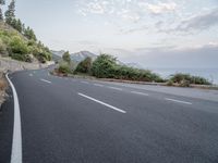 a empty road on a sunny day with white lines going through the center of the road