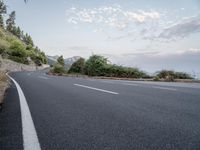 a empty road on a sunny day with white lines going through the center of the road