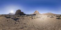 a desert area with rocky cliffs and bushes under a blue sky, under an arid area