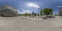 a panoramic photograph taken at a circular parking space in a public area with no cars or people