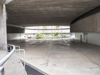 a parking garage with some stairs up to it for storage and safety and a bench next to the ramp