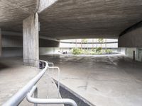 a parking garage with some stairs up to it for storage and safety and a bench next to the ramp