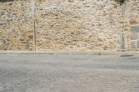 a man rides a skateboard on a city street while a woman watches from the side of the road