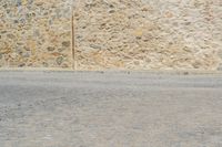 a man rides a skateboard on a city street while a woman watches from the side of the road