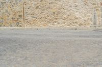 a man rides a skateboard on a city street while a woman watches from the side of the road