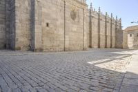 the old brick road between the large buildings is cobbled into stone blocks with an arch at the end