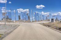 a row of large mirrors sitting on the side of a road next to a desert