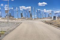 a row of large mirrors sitting on the side of a road next to a desert