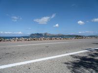 a road next to a wide body of water, and with rock - lined shoreline