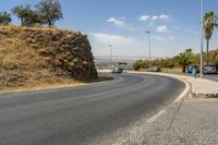 a hill with cars going down it near a road and traffic lanes with no traffic