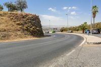 a hill with cars going down it near a road and traffic lanes with no traffic