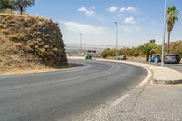 a hill with cars going down it near a road and traffic lanes with no traffic