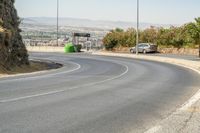 a hill with cars going down it near a road and traffic lanes with no traffic