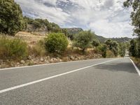 a motorcycle on a road going through some trees and mountains is seen here in the image