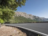 a bike is leaning against the road in a mountainous area and there are trees on either side of the road