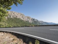 a bike is leaning against the road in a mountainous area and there are trees on either side of the road