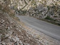 a black motorcycle is parked by the side of a mountain road in the middle of nowhere