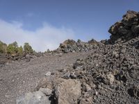 a man standing at the base of a large pile of rocks in a mountain range