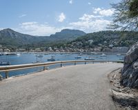 a paved road beside some large boats and a bridge with a bridge to the water