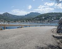 a paved road beside some large boats and a bridge with a bridge to the water