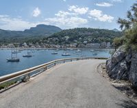 a paved road beside some large boats and a bridge with a bridge to the water