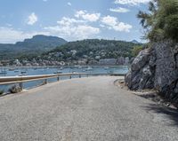 a paved road beside some large boats and a bridge with a bridge to the water